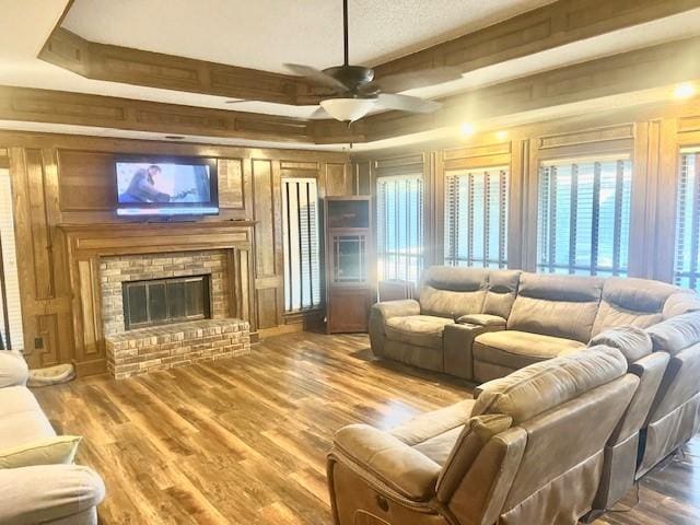 living room featuring hardwood / wood-style flooring, a brick fireplace, a wealth of natural light, and ceiling fan