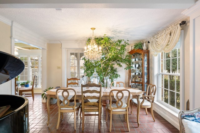 dining room with crown molding, a textured ceiling, and a chandelier