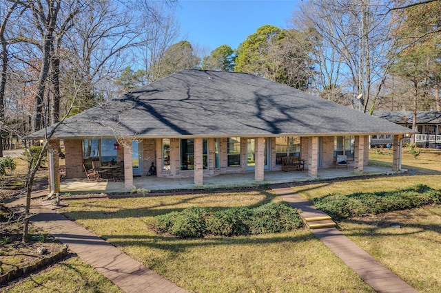 rear view of property with a patio and a lawn