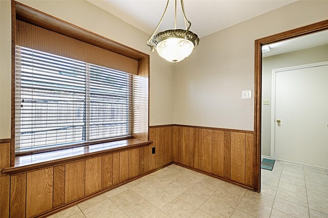 empty room with wainscoting and wooden walls