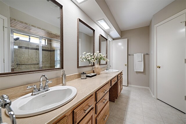 full bathroom with double vanity, a stall shower, tile patterned flooring, and a sink