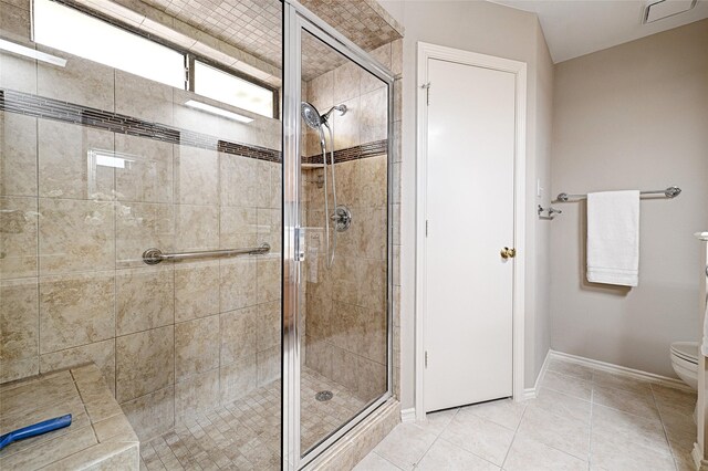 full bathroom featuring toilet, visible vents, baseboards, a shower stall, and tile patterned floors