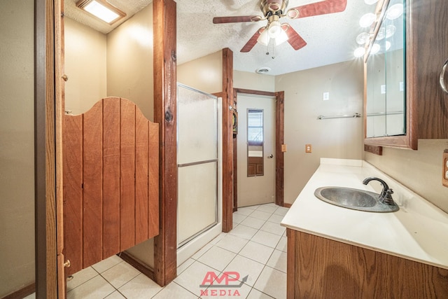 bathroom featuring walk in shower, tile patterned floors, a textured ceiling, vanity, and ceiling fan