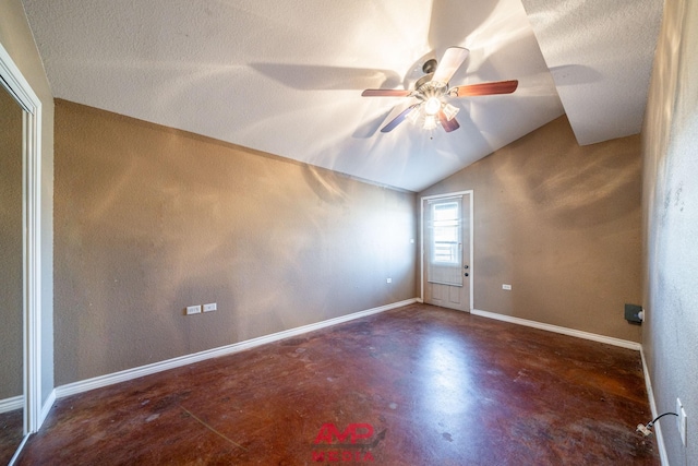 spare room featuring lofted ceiling, ceiling fan, and a textured ceiling