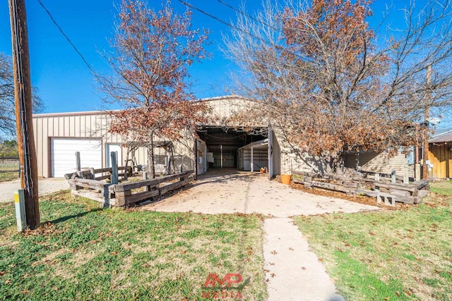 view of front facade with a garage, an outbuilding, and a front lawn