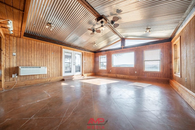 unfurnished room with french doors, lofted ceiling, wood walls, a wall unit AC, and ceiling fan