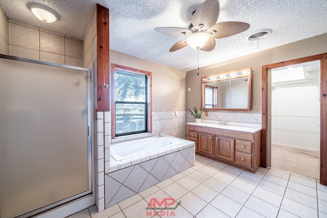 bathroom featuring independent shower and bath, vanity, tile patterned floors, and a textured ceiling