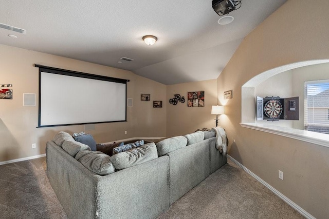 carpeted home theater room with lofted ceiling and a textured ceiling