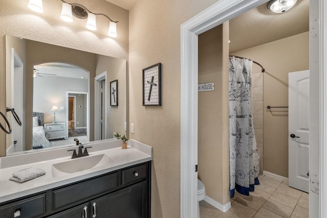 bathroom with walk in shower, vanity, toilet, and tile patterned flooring