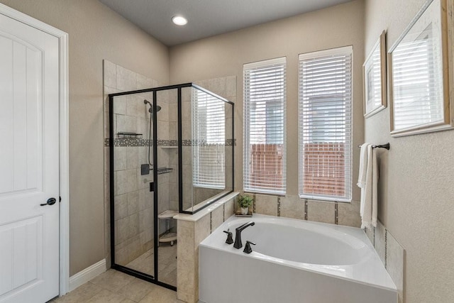 bathroom with separate shower and tub and tile patterned flooring