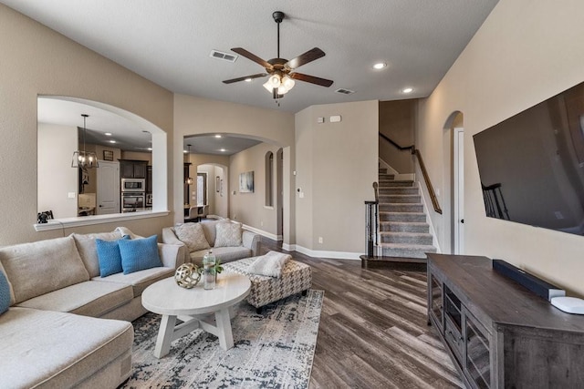 living room featuring a textured ceiling, wood-type flooring, and ceiling fan