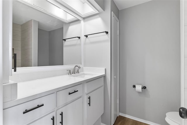 bathroom featuring hardwood / wood-style flooring, vanity, and toilet