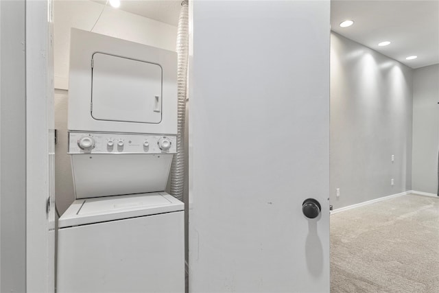 laundry room with stacked washer / dryer and carpet flooring