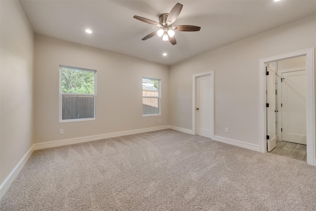 spare room with light colored carpet and ceiling fan