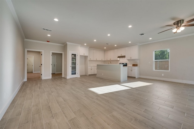 unfurnished living room featuring ceiling fan, ornamental molding, and light hardwood / wood-style floors