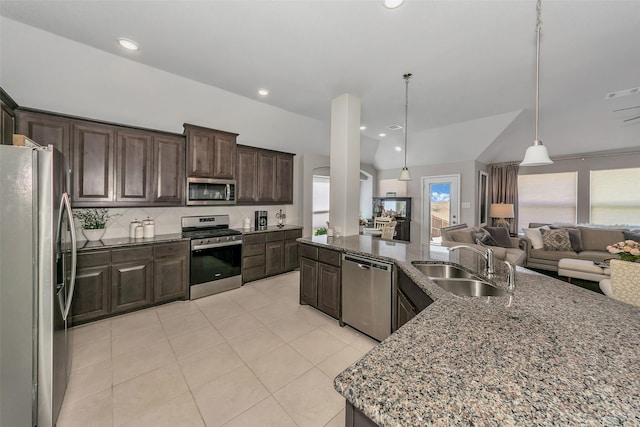 kitchen with appliances with stainless steel finishes, sink, light tile patterned floors, decorative light fixtures, and dark brown cabinetry