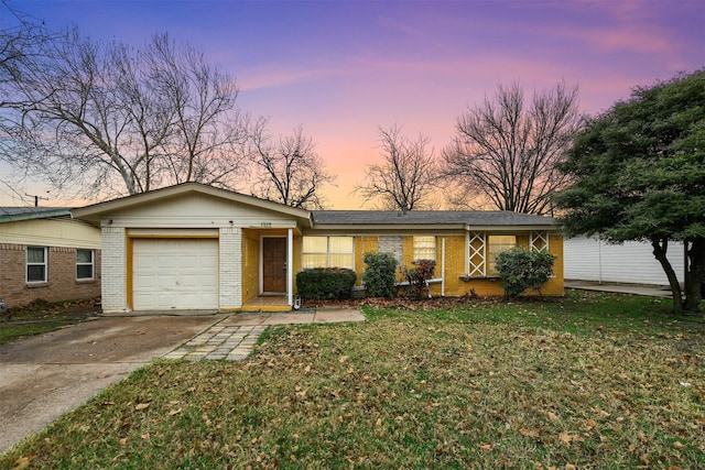 single story home with a garage and a lawn