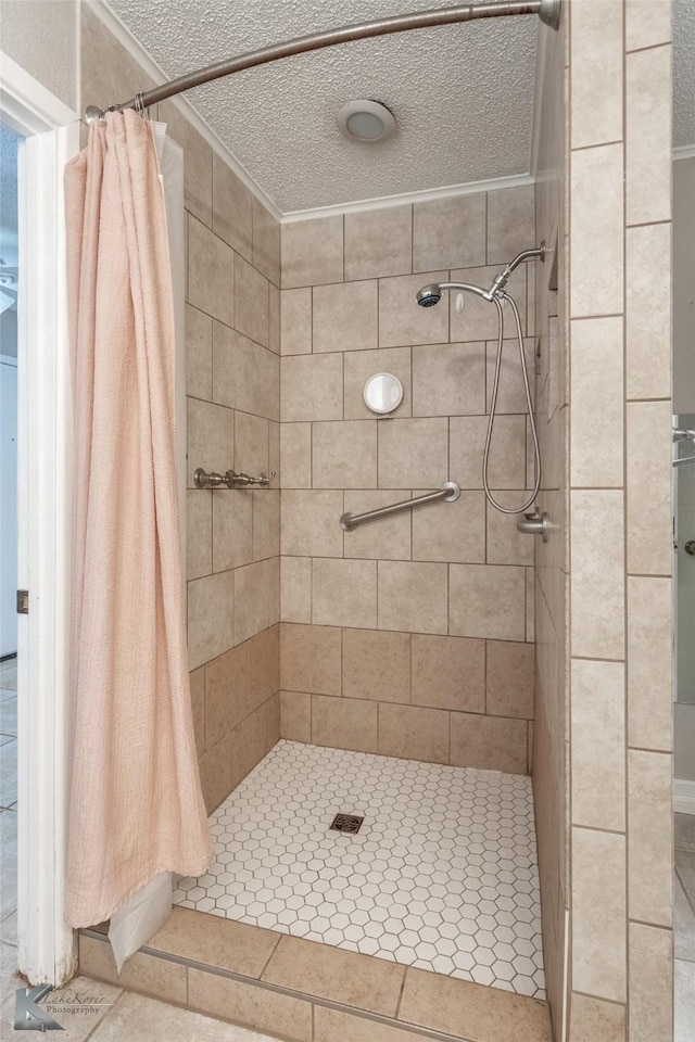 bathroom with a textured ceiling and a shower with shower curtain