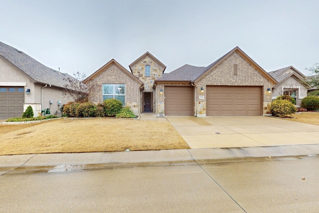 view of front of home with a garage, stone siding, concrete driveway, and brick siding