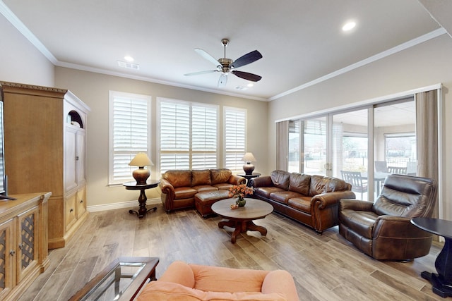 living room with ceiling fan, visible vents, baseboards, ornamental molding, and light wood finished floors