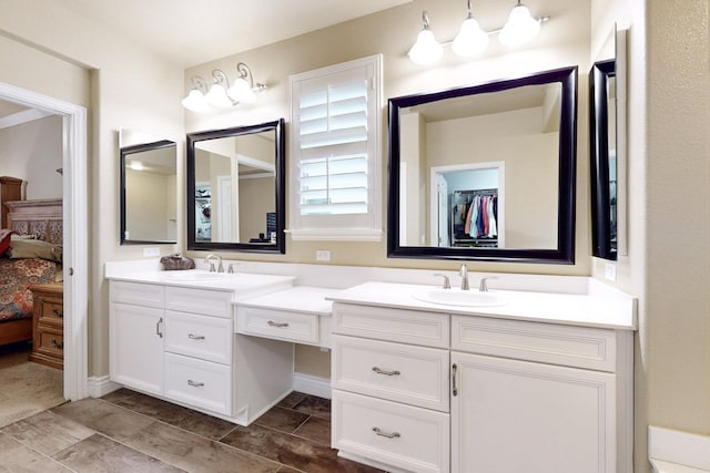 full bath with double vanity, a spacious closet, connected bathroom, and a sink