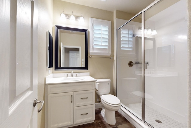 full bath with a stall shower, vanity, and toilet