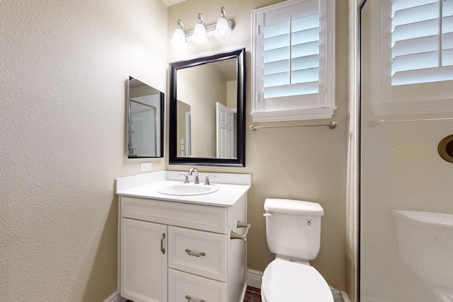 full bathroom with toilet, a textured wall, baseboards, and vanity