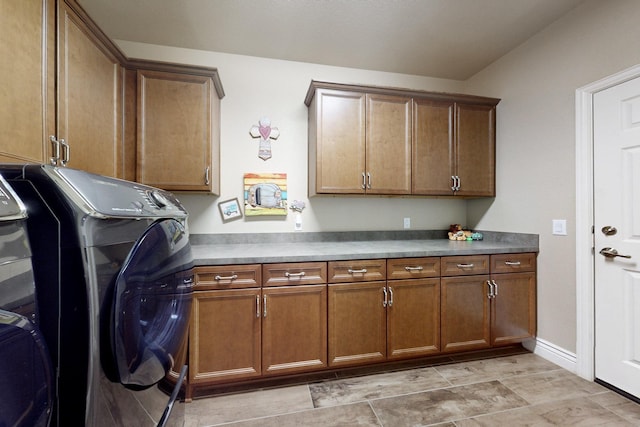 clothes washing area with washer and clothes dryer, cabinet space, and baseboards