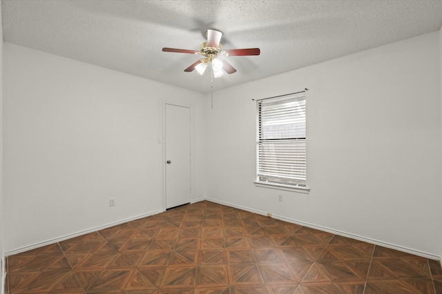 spare room featuring a ceiling fan, a textured ceiling, and baseboards