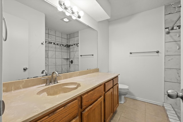 full bathroom featuring toilet, tile patterned flooring, a tile shower, and vanity