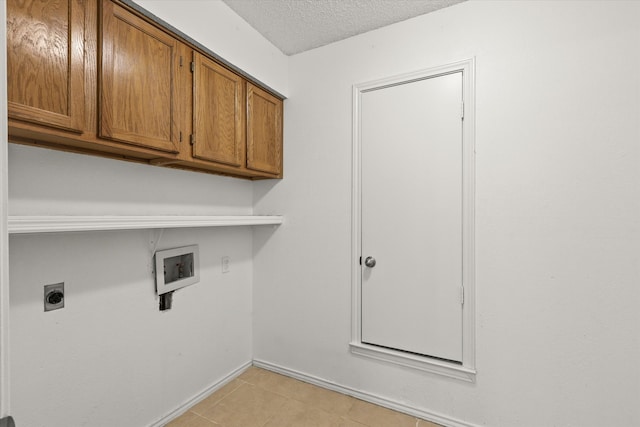 laundry area featuring light tile patterned floors, hookup for a washing machine, cabinet space, hookup for an electric dryer, and a textured ceiling