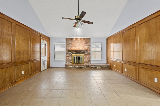 unfurnished living room featuring lofted ceiling, light tile patterned floors, a fireplace, and ceiling fan