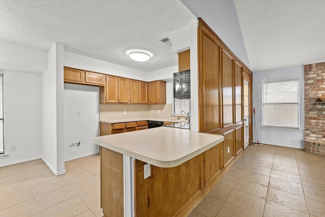 kitchen featuring light tile patterned floors, visible vents, brown cabinets, light countertops, and a textured ceiling