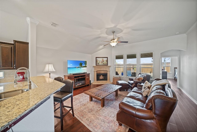 living room featuring dark wood-type flooring, ceiling fan, ornamental molding, and sink