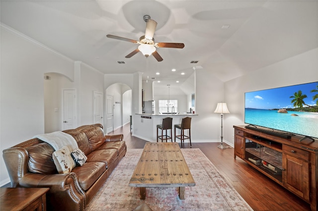 living room featuring lofted ceiling, sink, ceiling fan, hardwood / wood-style floors, and ornamental molding