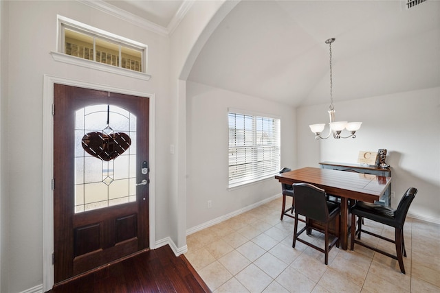 entryway with lofted ceiling, a notable chandelier, and ornamental molding