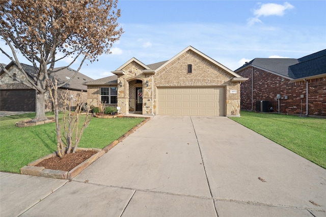 view of front of house featuring a garage, a front lawn, and central air condition unit