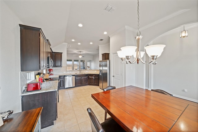 dining area with ceiling fan with notable chandelier, crown molding, sink, and light tile patterned floors