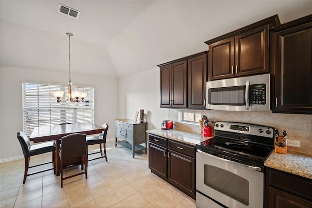 kitchen with backsplash, stainless steel appliances, light stone counters, dark brown cabinetry, and vaulted ceiling