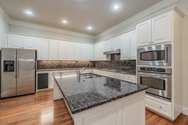 kitchen featuring sink, white cabinetry, light hardwood / wood-style flooring, an island with sink, and stainless steel appliances