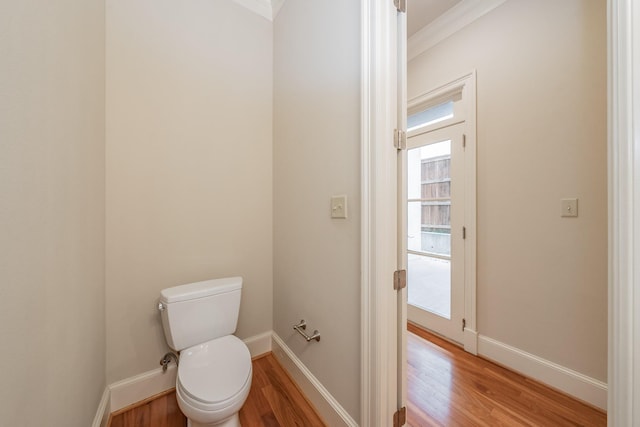 bathroom with ornamental molding, toilet, and hardwood / wood-style floors