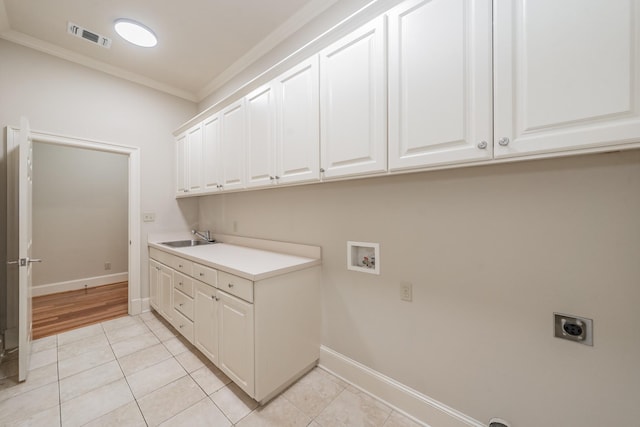 washroom with cabinets, light tile patterned flooring, electric dryer hookup, and sink