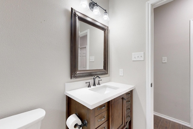 bathroom featuring vanity, hardwood / wood-style floors, and toilet