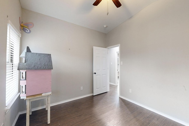 interior space featuring multiple windows, vaulted ceiling, and dark hardwood / wood-style floors