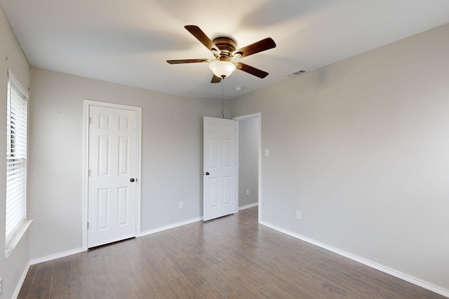 unfurnished bedroom featuring dark wood-type flooring and ceiling fan