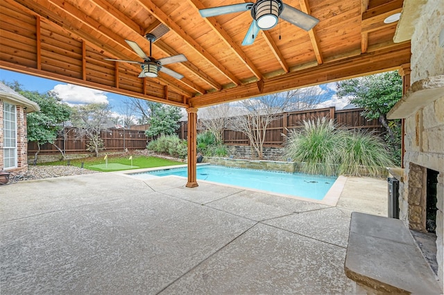 view of pool featuring an outdoor stone fireplace, ceiling fan, and a patio area