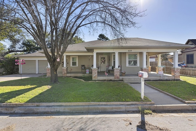 view of front of property with a porch, a garage, and a front lawn