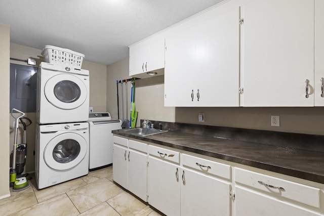 609 S Elm St, Weatherford, TX 76086 - laundry room with a sink, light tile patterned flooring, stacked washer and dryer, cabinet space, and a textured ceiling