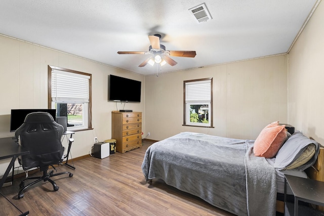 609 S Elm St, Weatherford, TX 76086 - bedroom with wood finished floors, visible vents, ceiling fan, and multiple windows