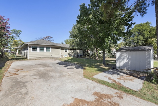 609 S Elm St, Weatherford, TX 76086 - view of front of home with concrete driveway, an outdoor structure, a front lawn, and a storage shed